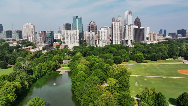 Panoramic view of high rise office or apartment buildings in metropolis. Public park with sports fields and lake. Atlanta, Georgia, USA