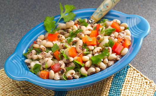 Bowl of black-eyed pea salad with cilantro and red bell pepper