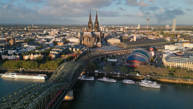 Aerial view Real time Footage of Cologne cathedral, Cologne Central Station and musical dome over Hohenzollern Bridge with  Train running at sunset time in Downtown of Cologne, Germany