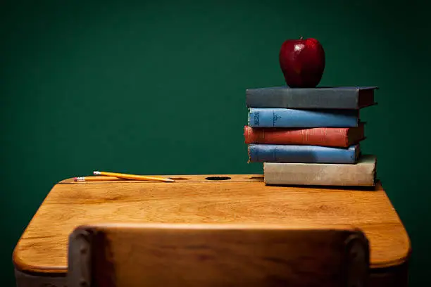 Photo of Apple, Pencils and Old Books on School Desk by Chalkboard