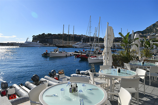 Monaco-ville, Monaco-11 22 2023: Tables on the terrace of a restaurant facing the harbor and marina of Monaco.