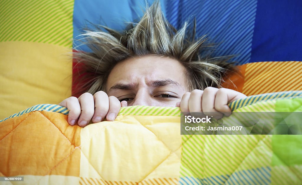 Teenager not wanting to get out of bed Teenager not wanting to get out of bed. Focus on eye. Teenager Stock Photo