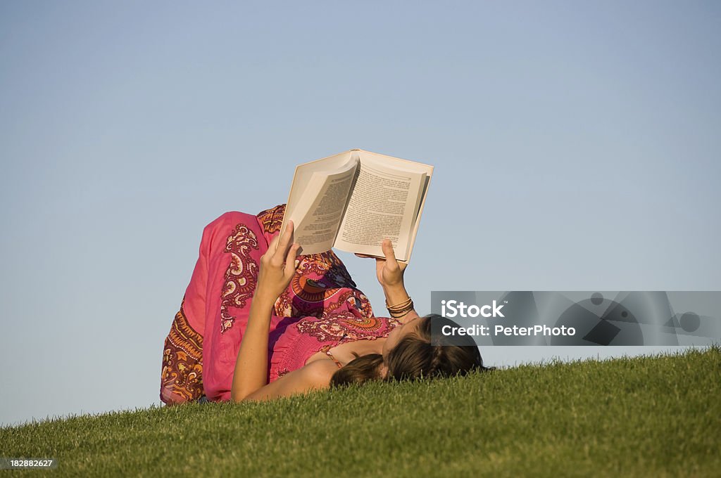 woman reading a book young female reading outdoors Adult Stock Photo