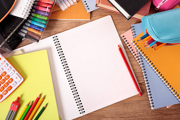 Mesa do estudante com o caderno aberto em branco - foto de acervo