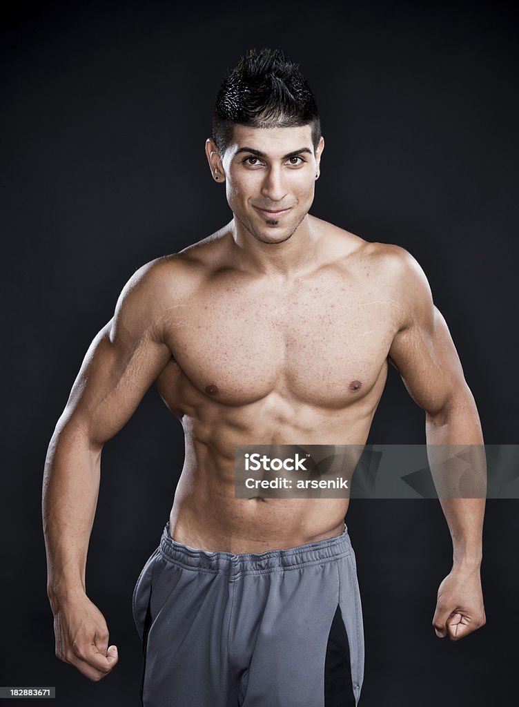 Bodybuilder Athletic male with muscular physique on black background. Abdominal Muscle Stock Photo