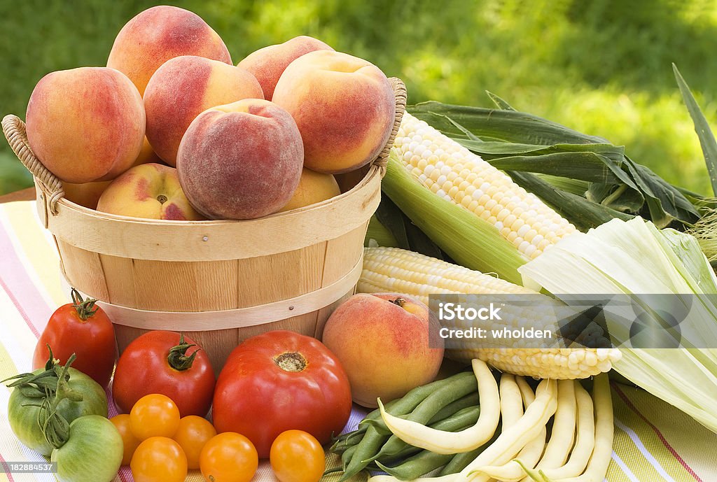 Local Summer Produce "Fresh locally grown summer produce is displayed against a garden backdrop.  The produce includes peaches, corn,green beans, wax beans and several varieties of tomatoes picked at the peak of ripeness." Corn Stock Photo