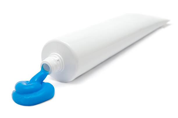 Tube of Toothpaste Blue toothpaste. White background. Shallow depth of field. white plastic tube stock pictures, royalty-free photos & images