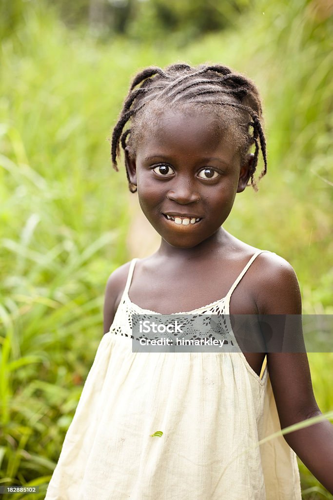 African Girl An African girl standing in tall grass smiling at the camera. Africa Stock Photo