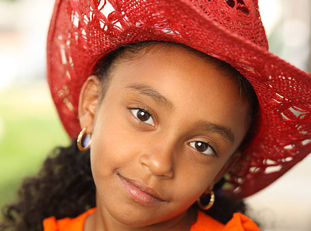 Young Little Girl Young latina girl wearing an adult cowboy hat.For more images of this model puerto rican ethnicity stock pictures, royalty-free photos & images