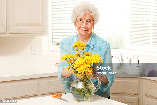 Starszy Kobieta Organizowanie Krój Żółte Kwiaty W Wazon - zdjęcia stockowe i więcej obrazów 80-89 lat