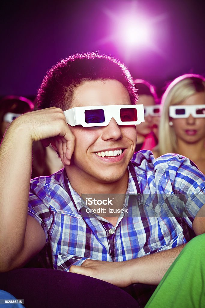 Young man in movie theater "Young adult man wearing 3D glasses, sitting in the cinema and watching 3D movie. He laughing and having fun." 3-D Glasses Stock Photo