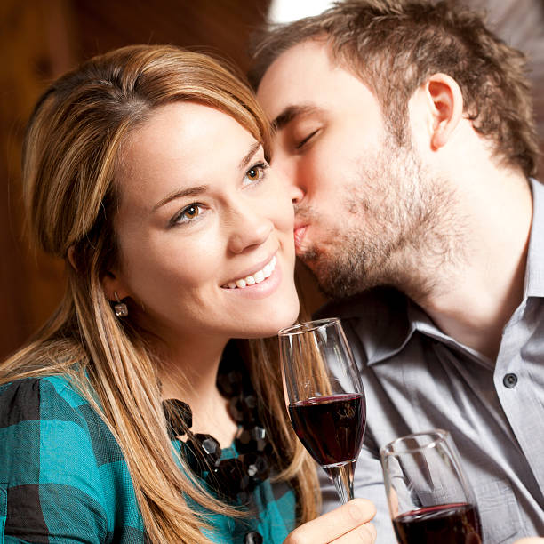 istock Young Man Kissing Woman While Drinking at Restaurant 182886279