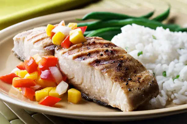 "SEVERAL MORE IN THIS SERIES. Grilled cutlet (open steak cut) of mahi-mahi (dolphin fish) with a fresh mango, pepper and onion salsa; rice and green beans on the side."