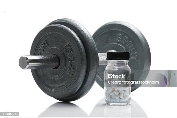 Jar Of White Anabolic Steroids Next To A Dumbbell Stock Photo - Download Image Now - Beauty, Crime, Dumbbell