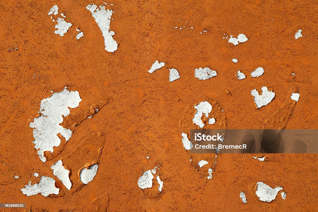 Old orange paint Weathered white painted wall with layer of peeling orange paint. Abandoned Stock Photo