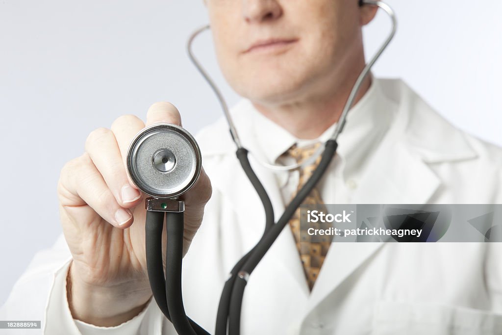 Doctor with Stethoscope A doctor holds up a stethoscope. Adult Stock Photo