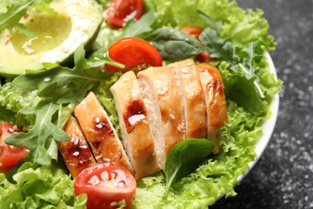 istock Delicious salad with chicken, cherry tomato and avocado on table, closeup 1828893261