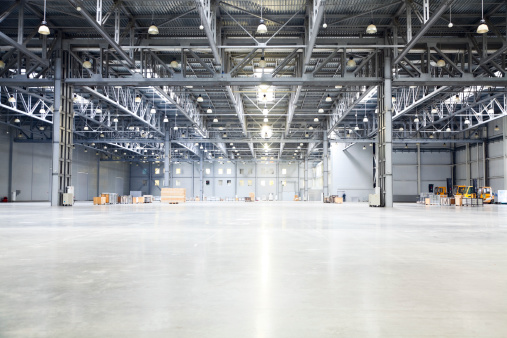 empty room of modern storehouse with forklift truck loader on a foreground and office rooms