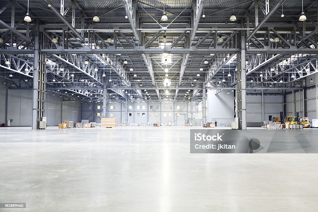 empty room of modern storehouse empty room of modern storehouse with forklift truck loader on a foreground and office rooms Warehouse Stock Photo