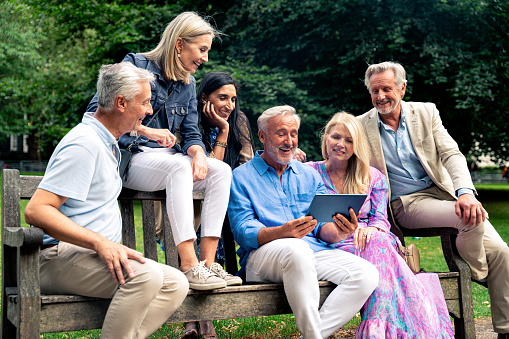 Group of old friends spending time together in the main parts of London, visiting the Westminster area and St. James Park. Old buddies reunion. Concept about third age and seniority