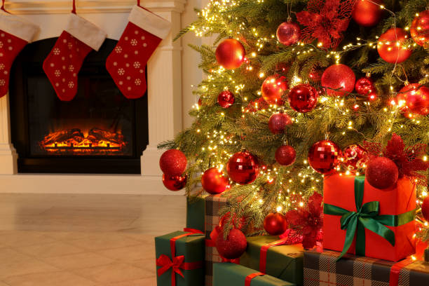 istock Many gift boxes under decorated Christmas tree and fireplace indoors 1828898005