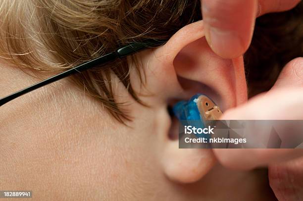 Inserting Completely In The Canal Hearing Aid Childs Ear Stock Photo - Download Image Now