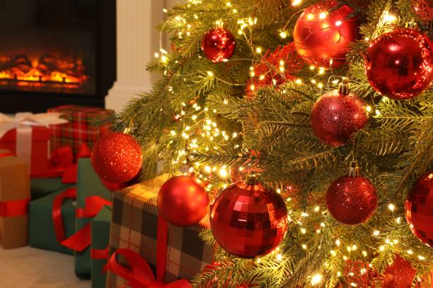 istock Many gift boxes under decorated Christmas tree and fireplace indoors 1828900209