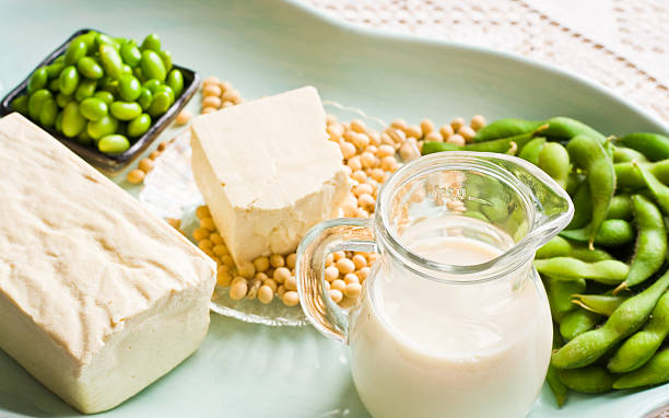 latte di soia e soia prodotti disposte su un vassoio di acqua - soybean merchandise soy milk milk foto e immagini stock