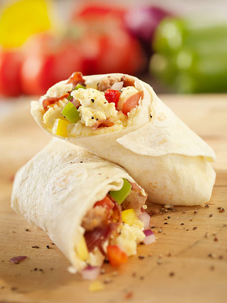 Breakfast Burrito with Scrambled Eggs "Breakfast Burrito with Scrambled Eggs, Bacon, Sausage, Tomatoes and Peppers -Photographed on Hasselblad H3D2-39mb Camera" burrito photos stock pictures, royalty-free photos & images