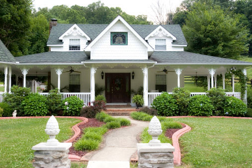 Victorian-style home with wraparound porch in country setting