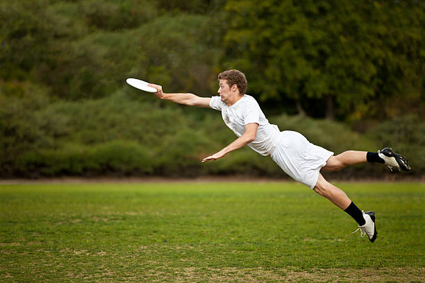 jovem atraente frisbee - plastic disc ultimate competition determination - fotografias e filmes do acervo