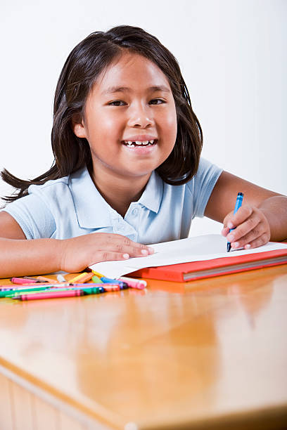 niño con libro para colorear con crayons escritorio - schoolgirl little girls crayon human face fotografías e imágenes de stock