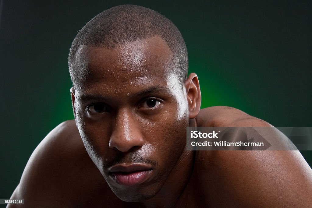 African American Boxer Sweating After a Strenous Workout An African American boxer looking directly into the camera with sweat dripping from his brow after a strenous workout getting ready for his next fight. Sweat Stock Photo