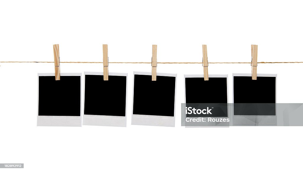 Blank instant photo prints on a washing line Several blank instant photo prints hanging on a rope or washing line. Isolated on white background Instant Print Transfer Stock Photo