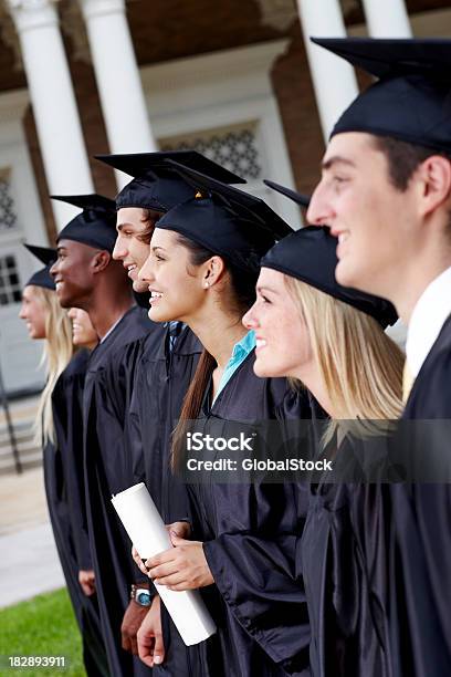 Sonriendo Estudiantes Graduados De Pie En Una Línea Foto de stock y más banco de imágenes de 18-19 años