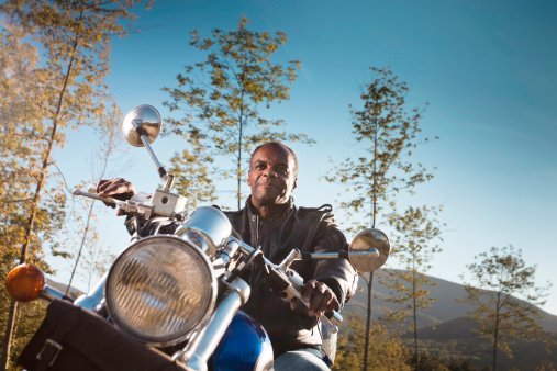 African American Man riding motorcycle on late summer/early fall evening