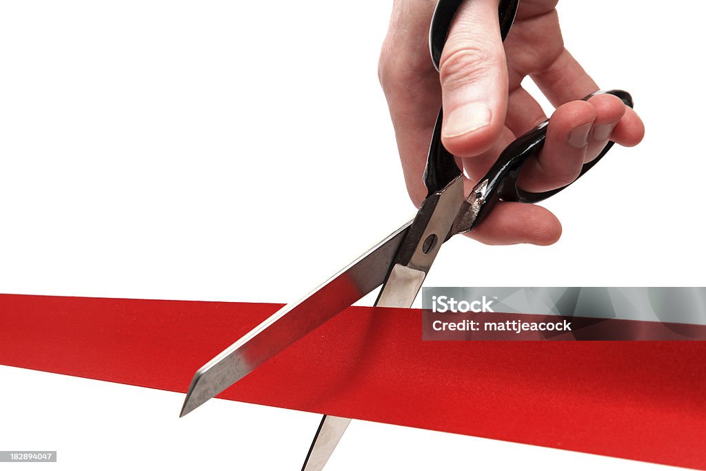 Up-close shot of scissors cutting through a red ribbon scissors cutting a red ribbon - opening ceremony concept Cutting Stock Photo