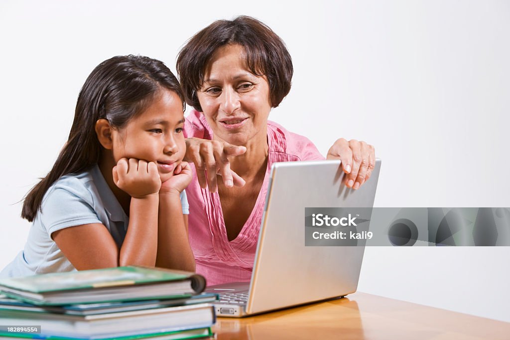 Insegnante aiutando bambine con computer portatile - Foto stock royalty-free di Sfondo bianco