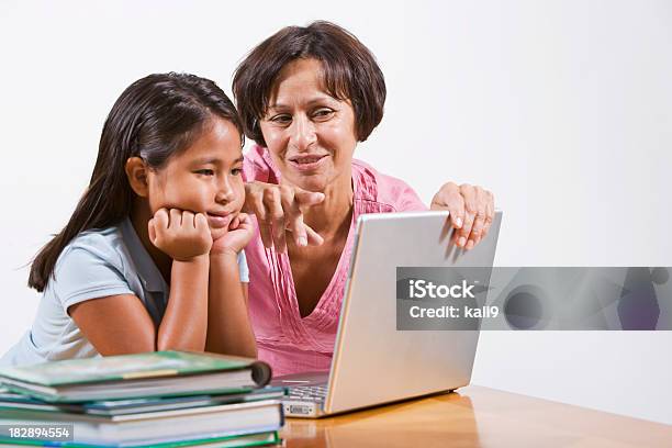 Insegnante Aiutando Bambine Con Computer Portatile - Fotografie stock e altre immagini di Sfondo bianco - Sfondo bianco, Insegnante, Educazione