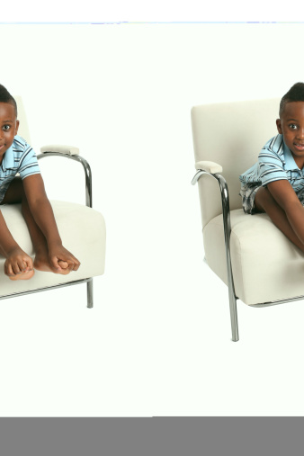African American boy with funny expression playing with feet. Shallow DOF with focus on feet/hands. Isolated on White.