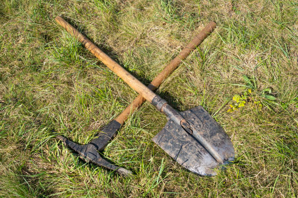istock Pick and spade lying in green grass 1828947848