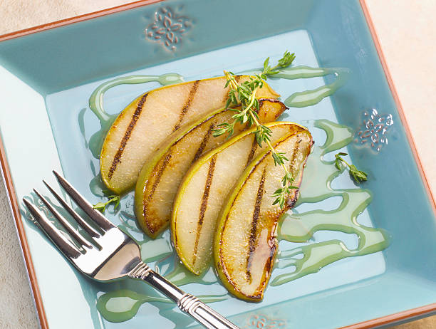 Grilled Pears with honey & thyme dessert plate stock photo