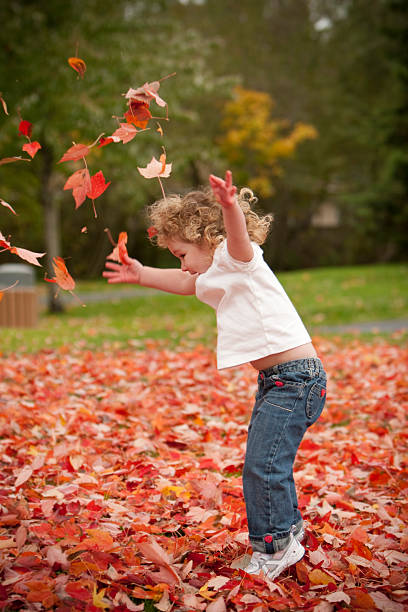 istock Girl throwing leaves 182894964