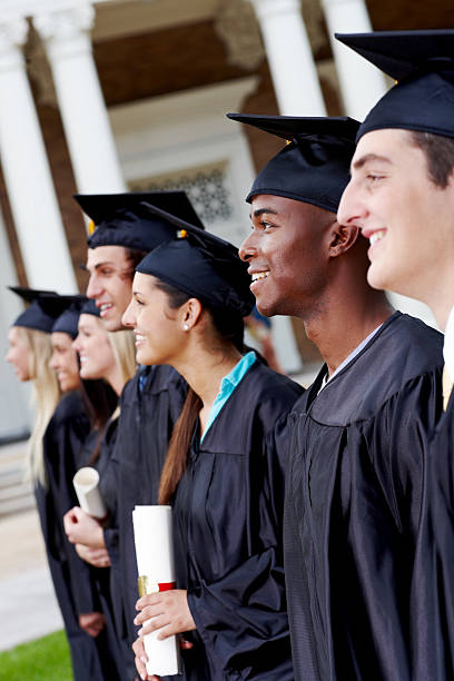 istock Side view of smiling young graduates standing in a line 182895923