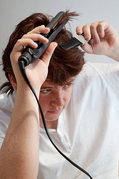 istock teenage boy using hair straighteners 182896276