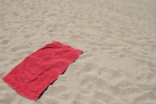 Red towel on sandy beach