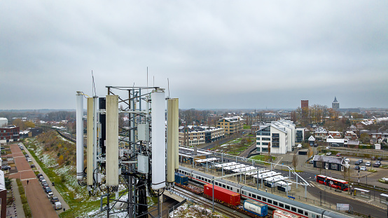 Oldenzaal, Netherlands - December 2, 2023: mobil phone communication tower high above the village and local train station.