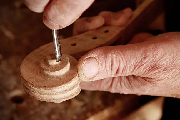 Violin maker working on a scroll.