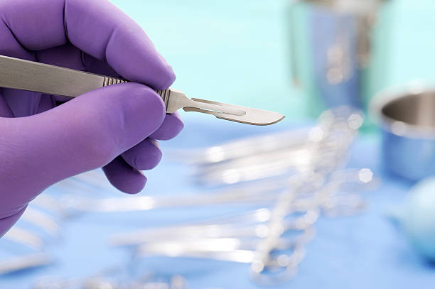 Close-up of surgial scalpel Close-up of gloved hand with surgical scalpel against other medical instruments Scalpel stock pictures, royalty-free photos & images