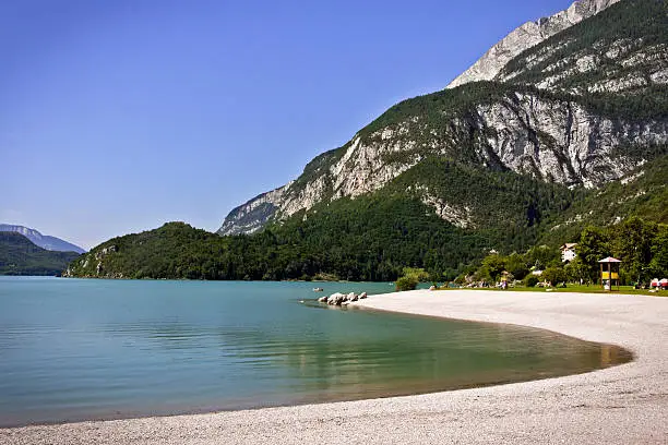 The beach and the clean water of the Molveno lake. The location is the Dolomiti del Brenta (Trentino-Alto Adige, Italy) during the summer season.